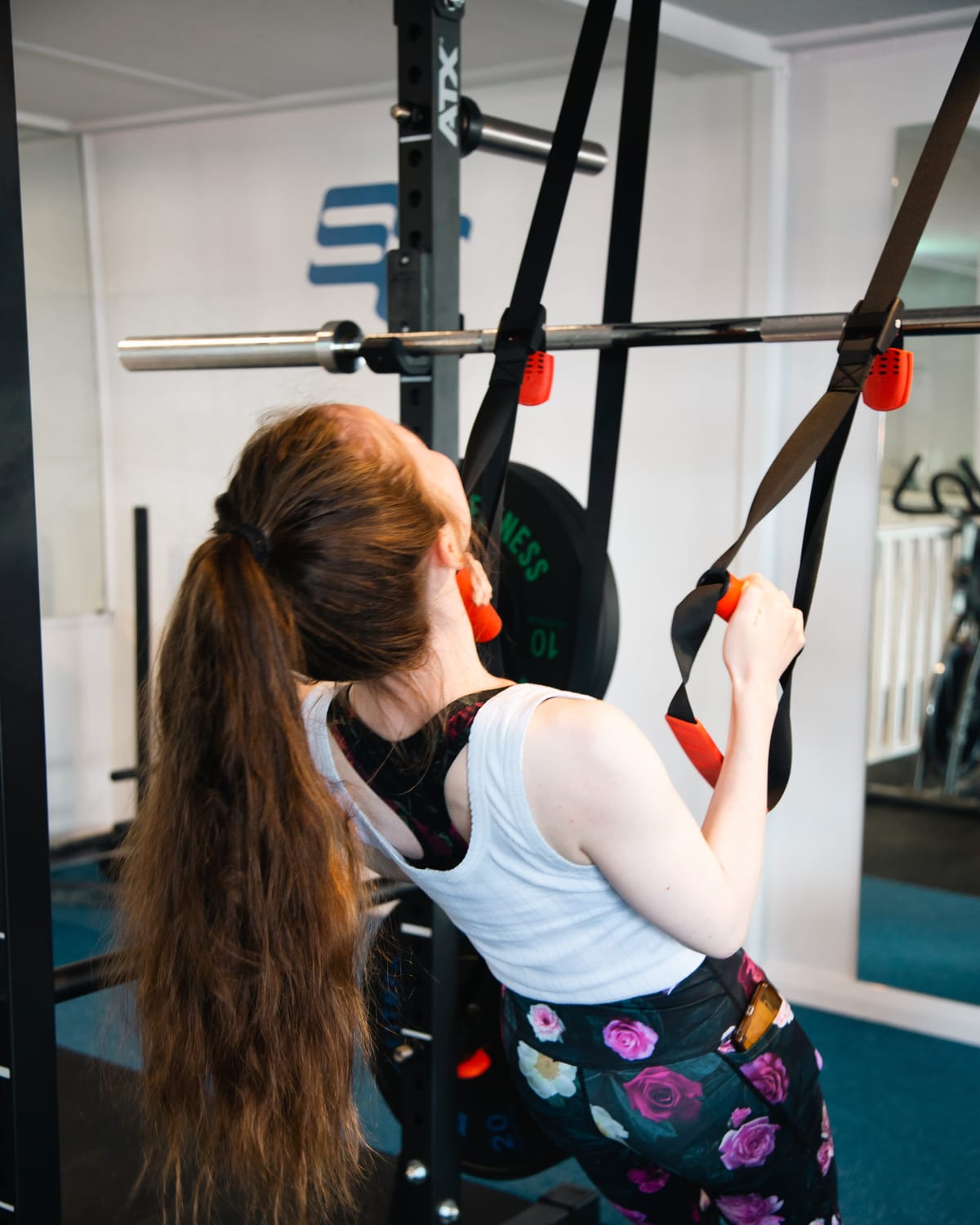 Suspension trainer row in the squat rack, working the shoulder blade muscles